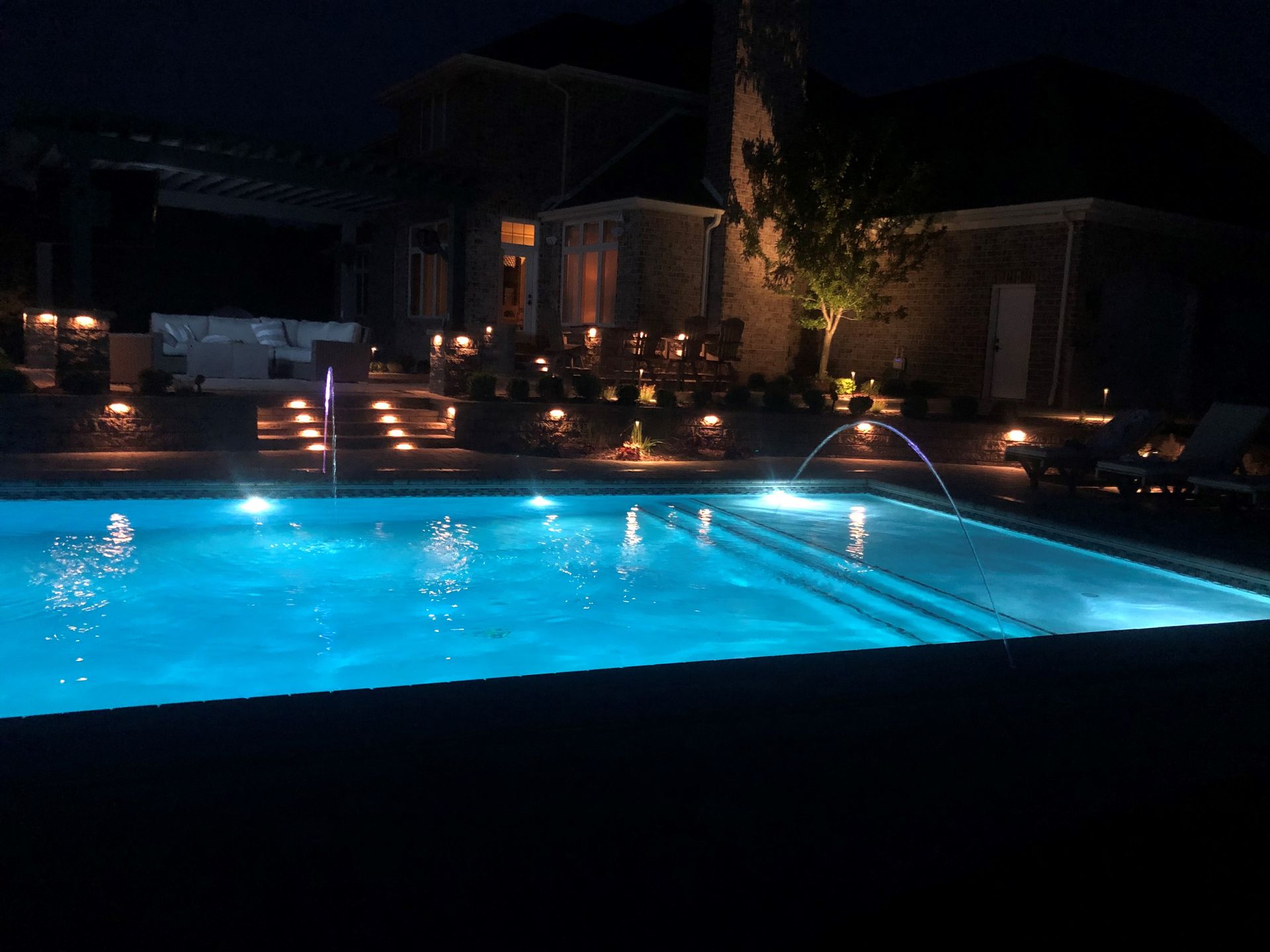 A large swimming pool is lit up at night