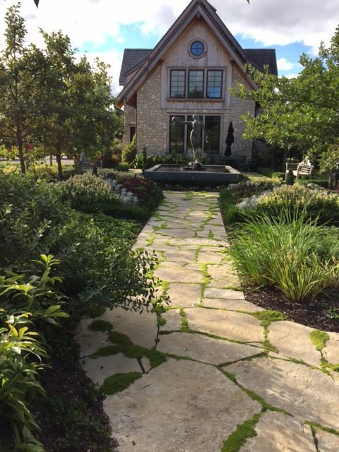 A stone walkway leading to a large house