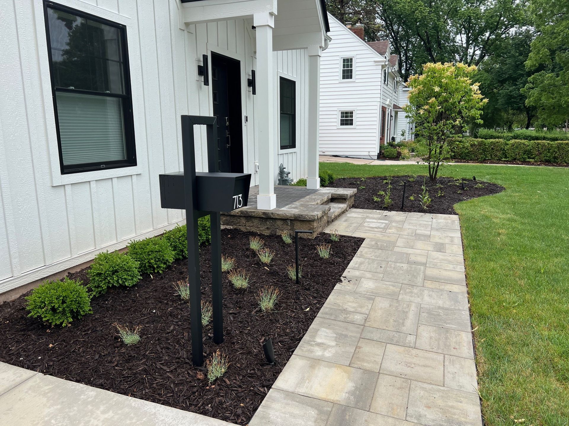 A white house with a black mailbox in front of it