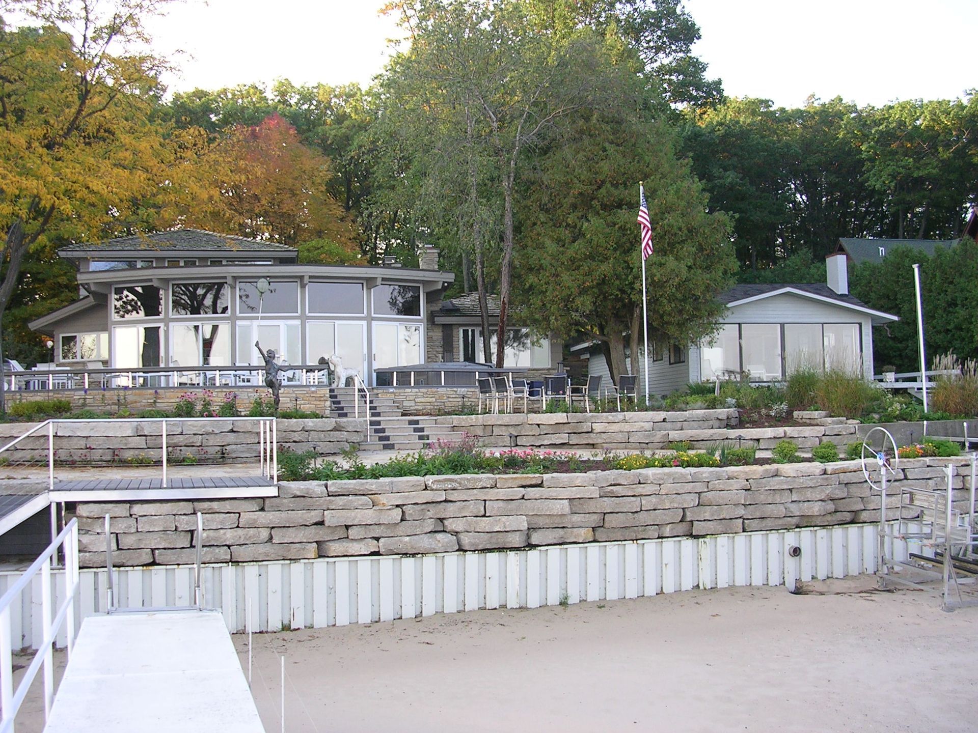 A large house sits on the shore of a lake