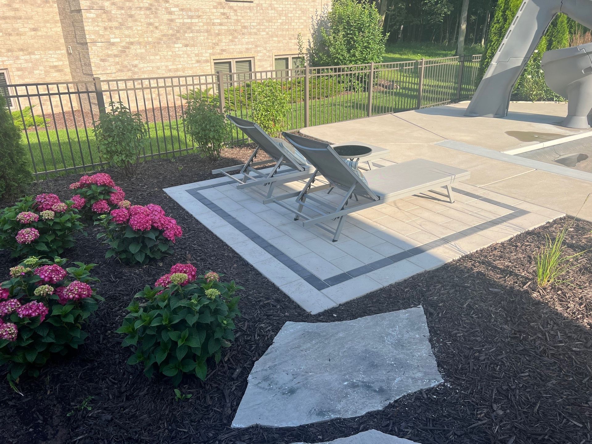 A patio with chairs and flowers in front of a house