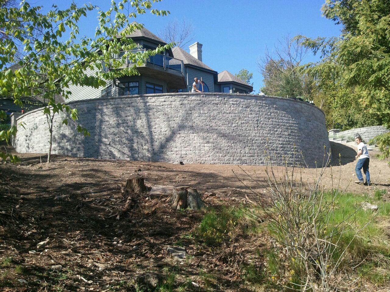 A large house with a large stone wall in front of it