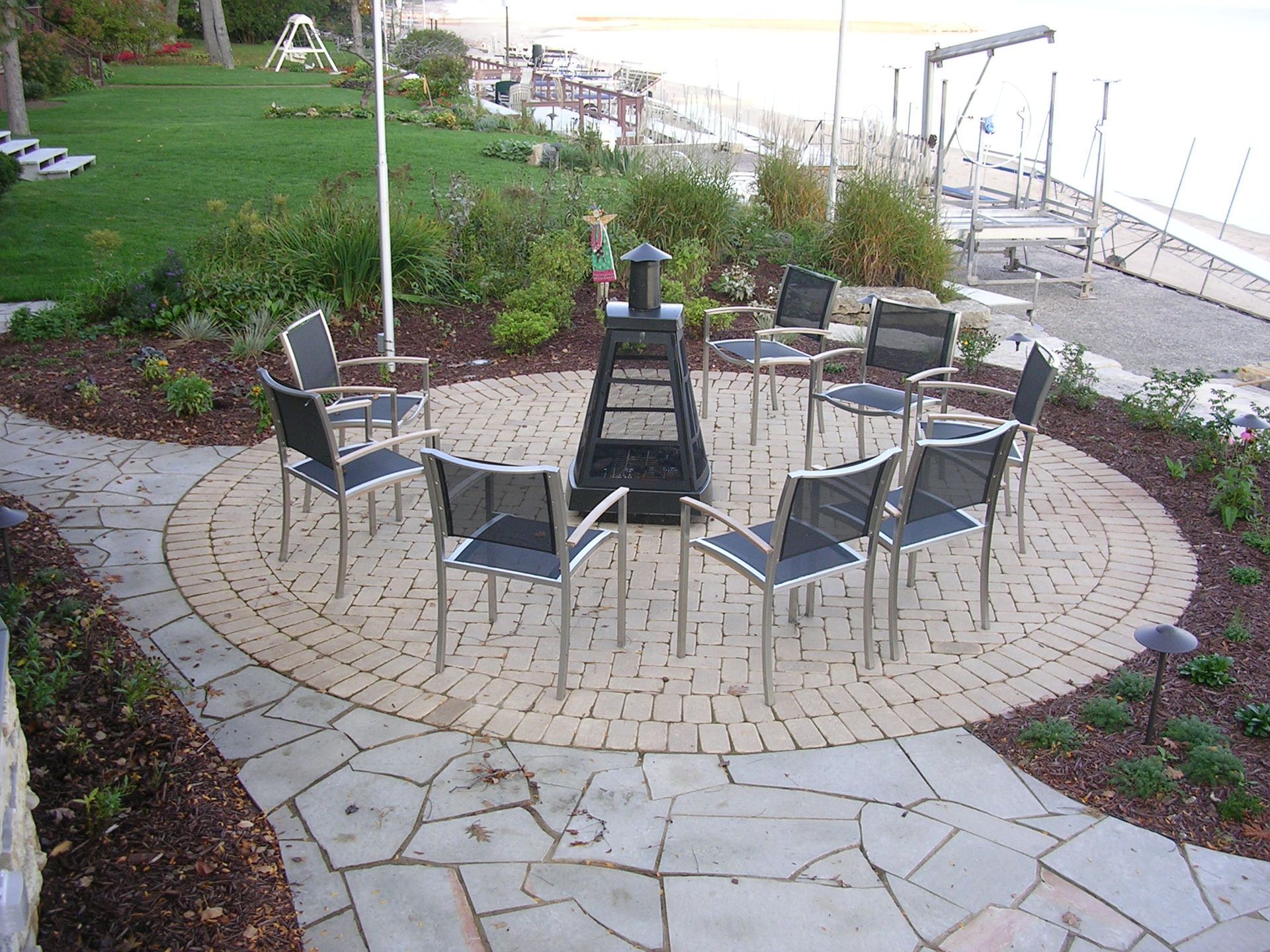 A patio with chairs and a fire pit in the middle