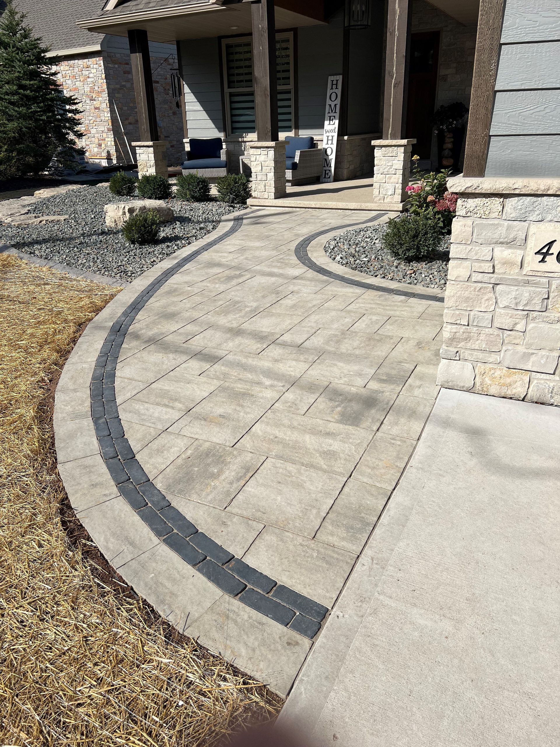 A brick walkway leading to a house