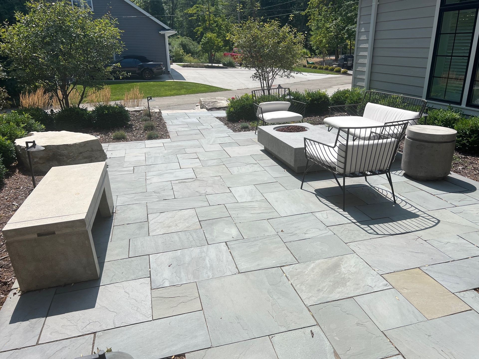 A patio with chairs and a table in front of a house