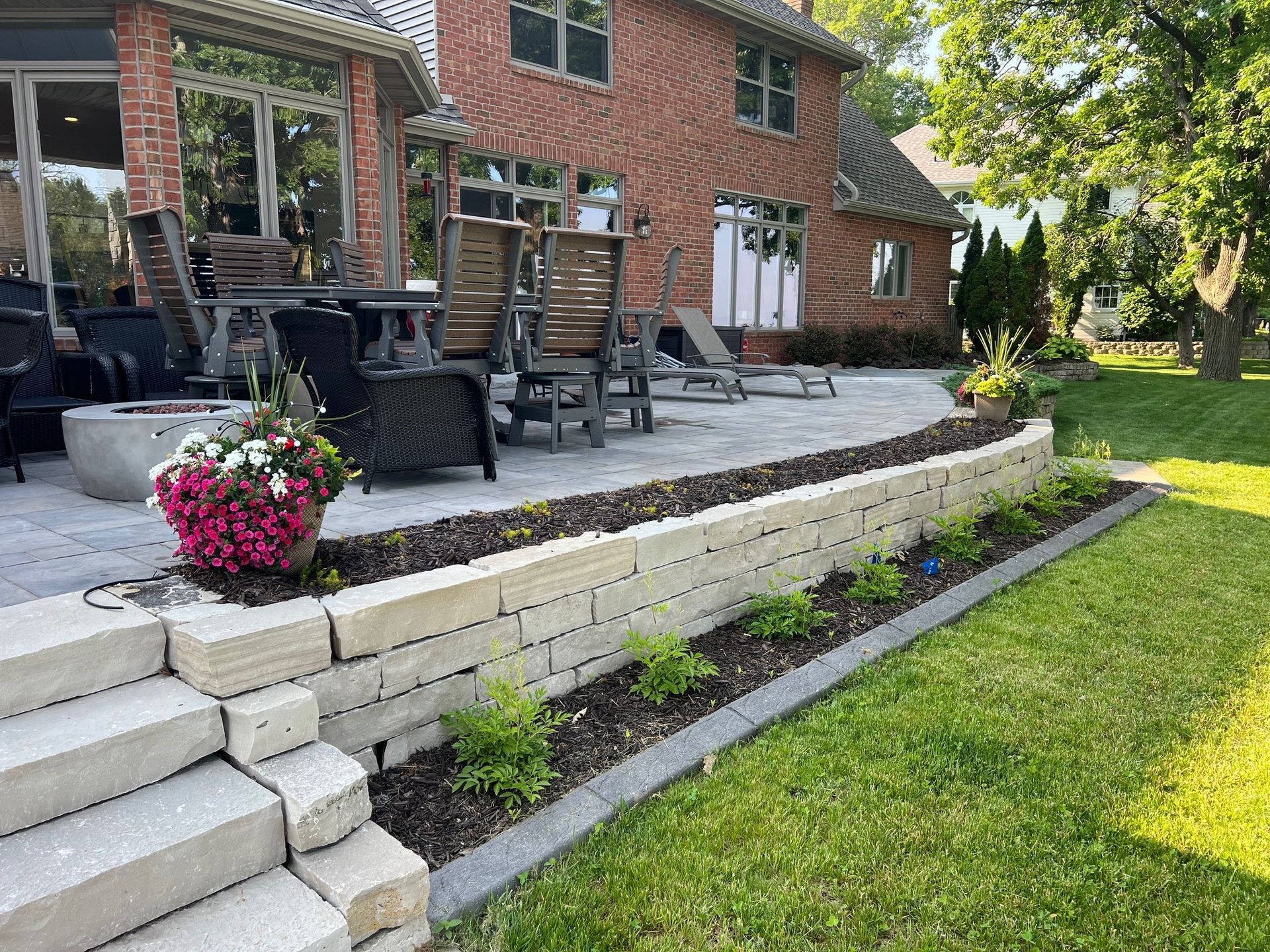 A brick house with a patio and chairs in front of it