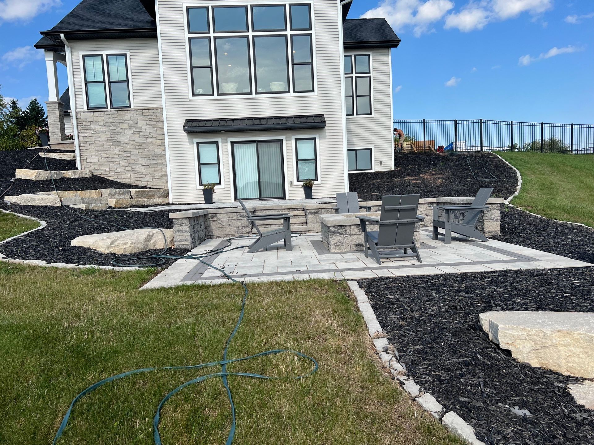 A large white house with a patio and chairs in front of it