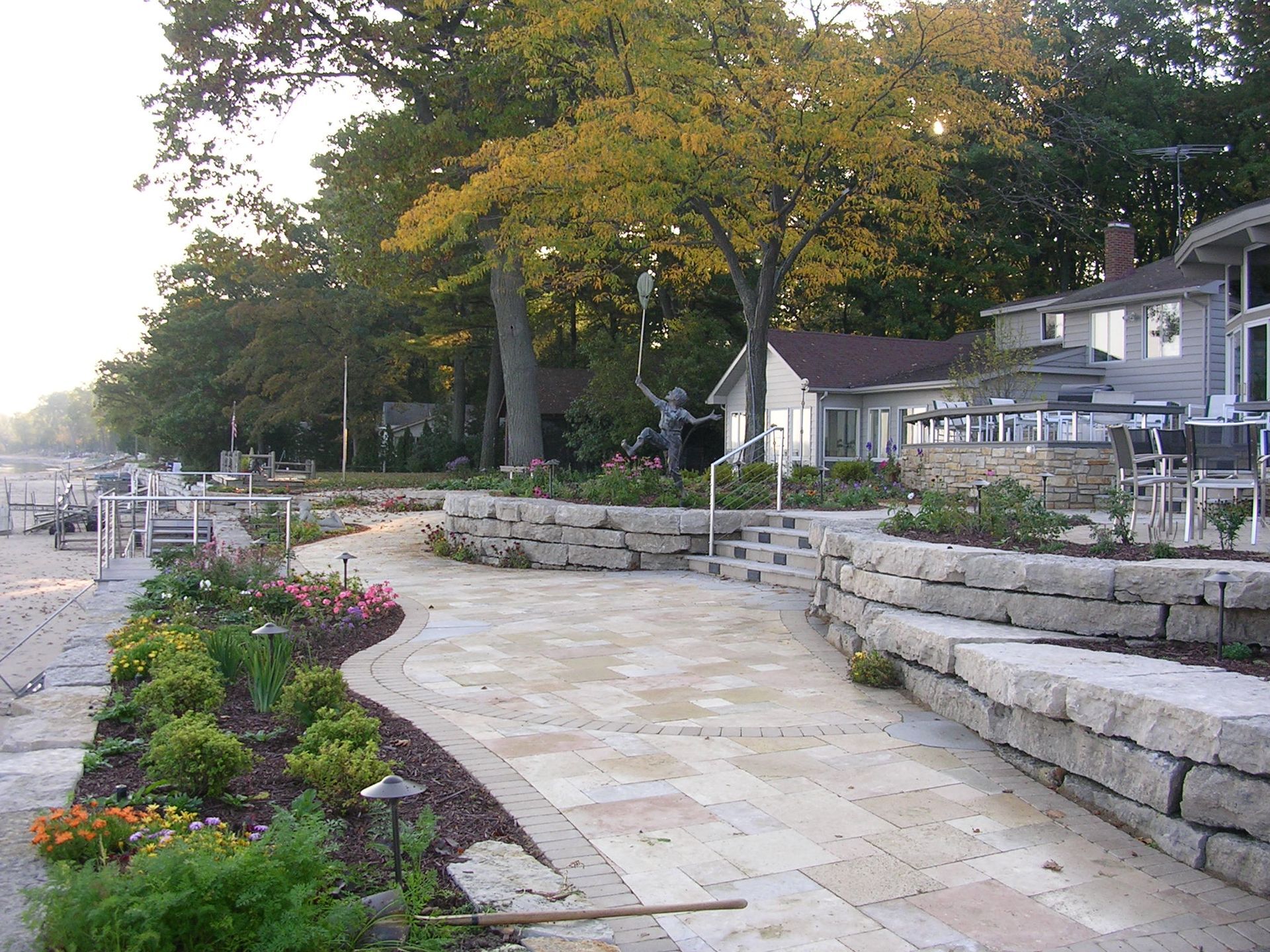 A stone walkway leading to a house surrounded by trees