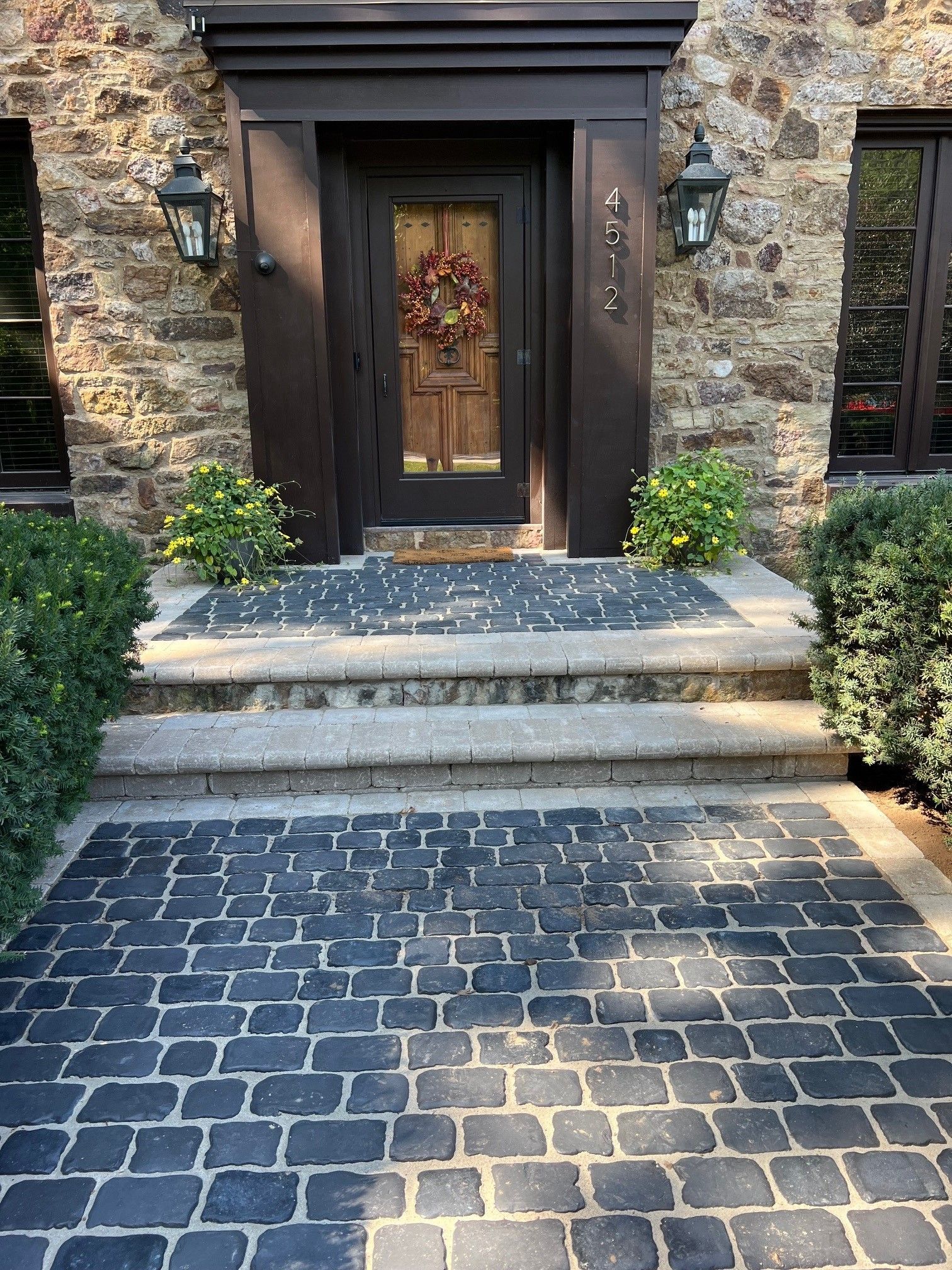 There is a brick walkway leading to the front door of a house