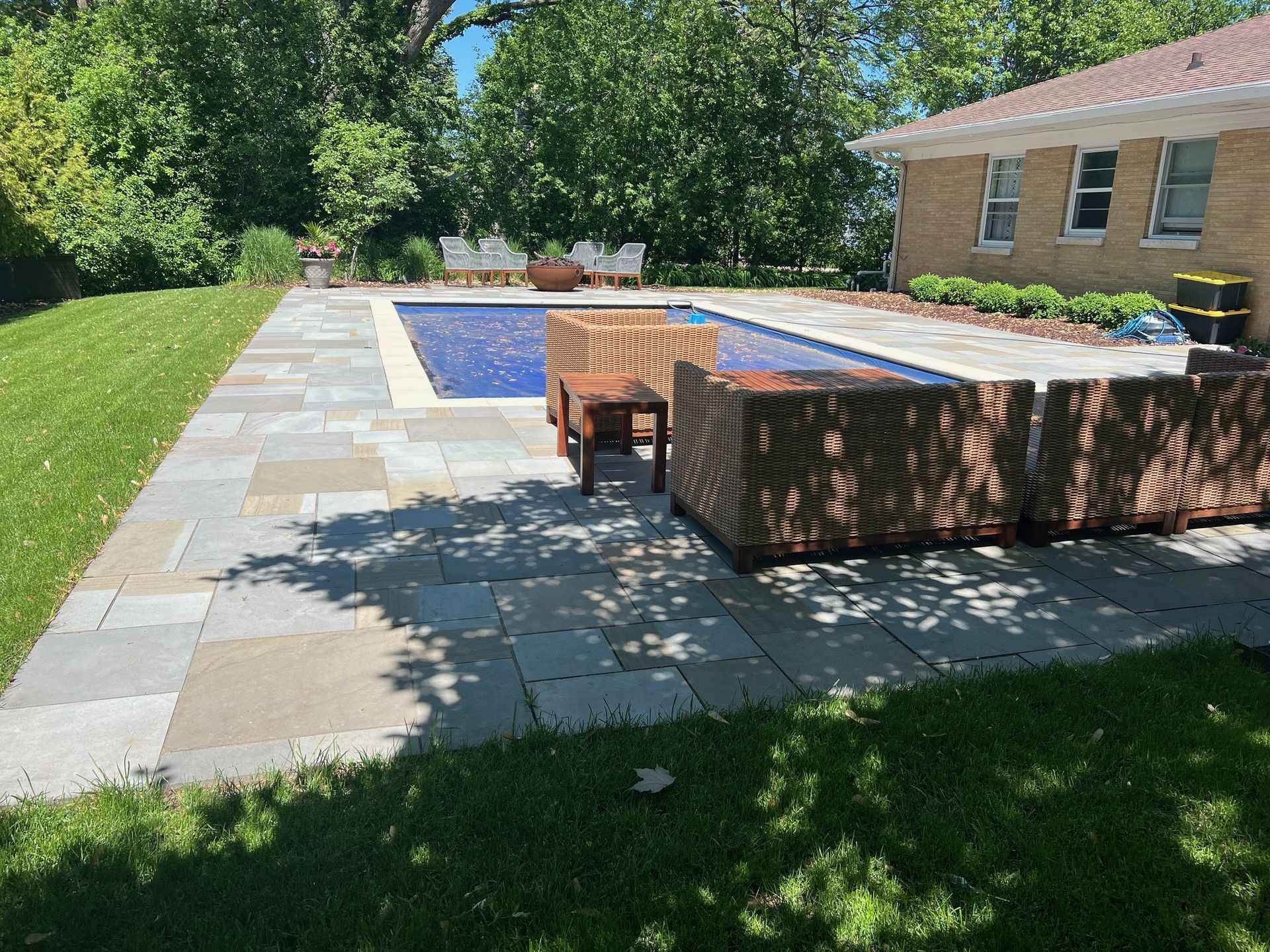 There is a large swimming pool in the backyard of a house