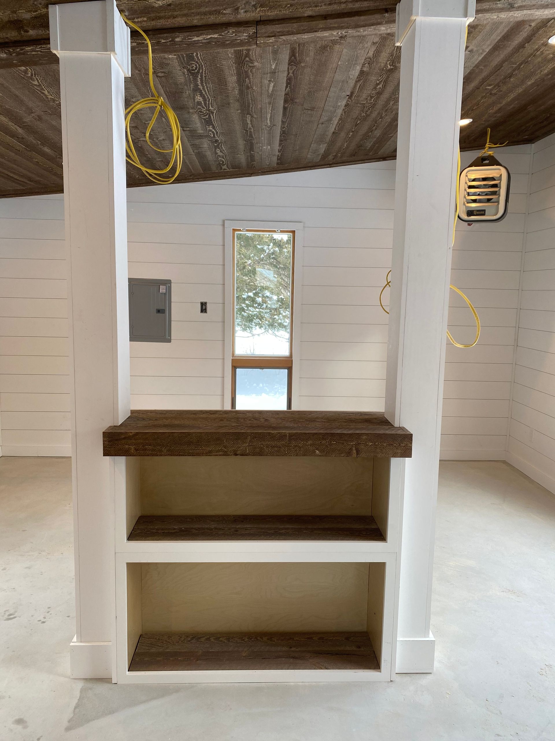 Rustic white interior with wooden counters and a small central window opening to outdoors