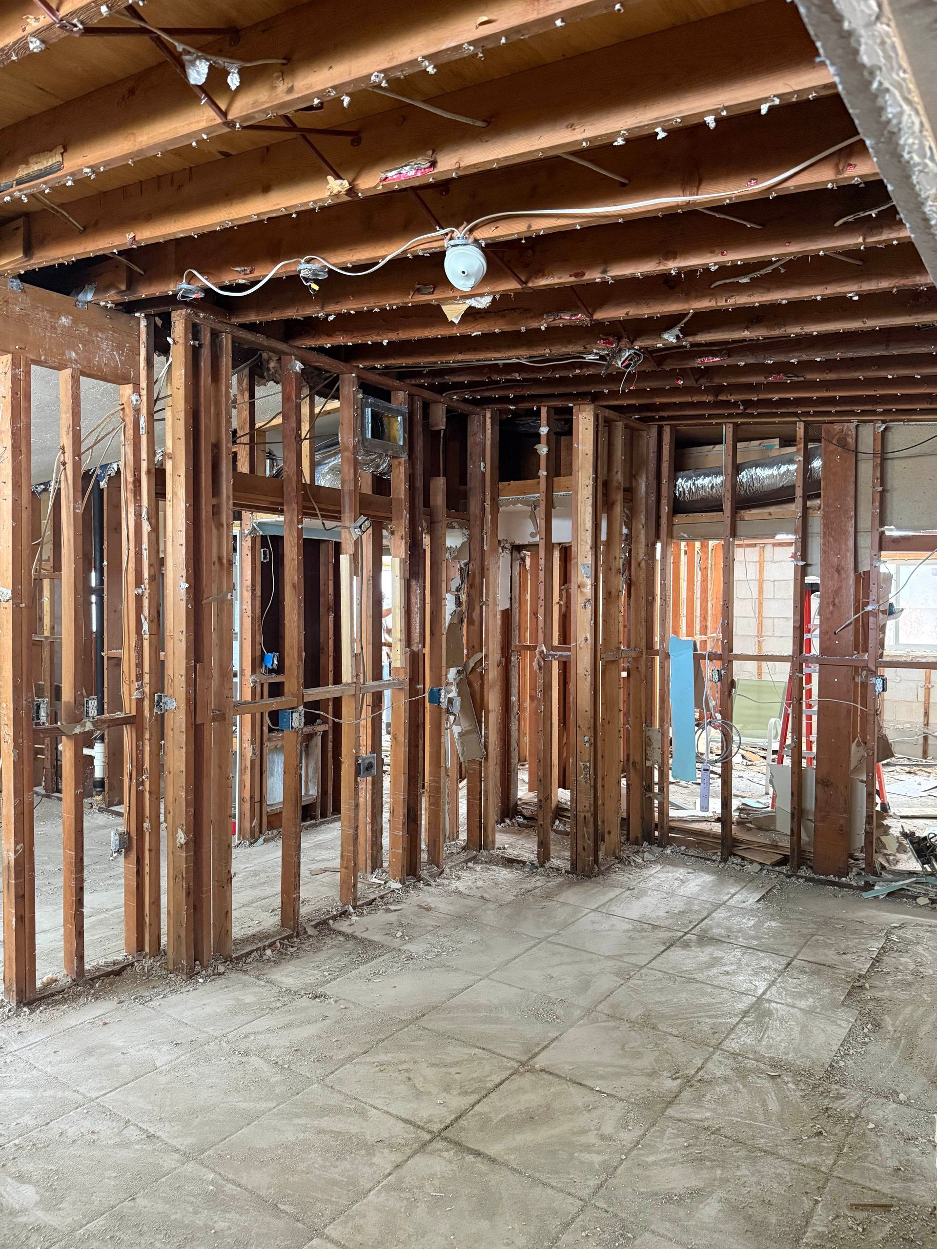 Exposed wooden framing and concrete floor inside a house under construction