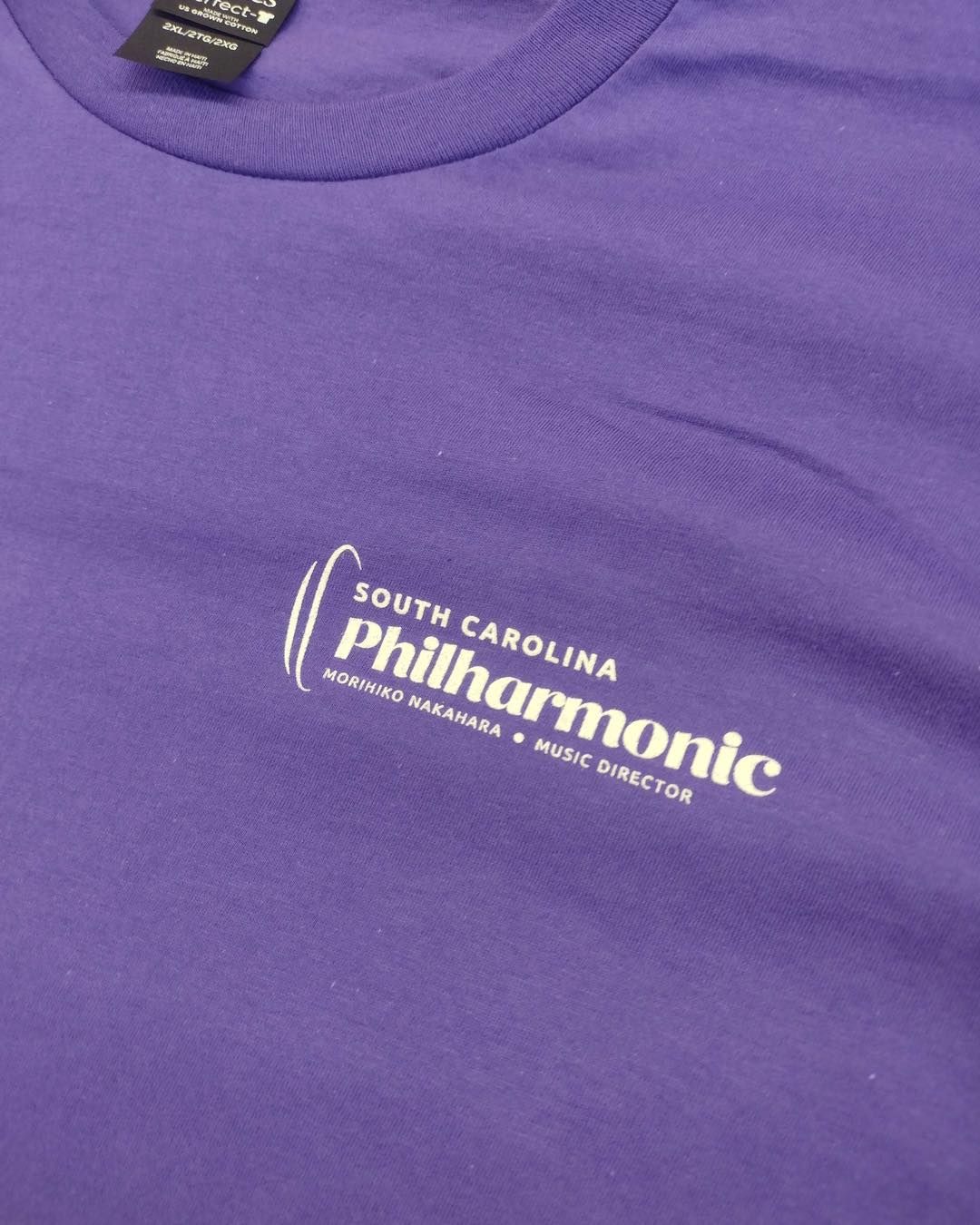 Purple t-shirt with the South Carolina Philharmonic logo in white on the chest.