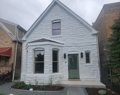 A white brick house with a green door