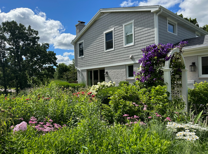 A house with a lot of flowers in front of it