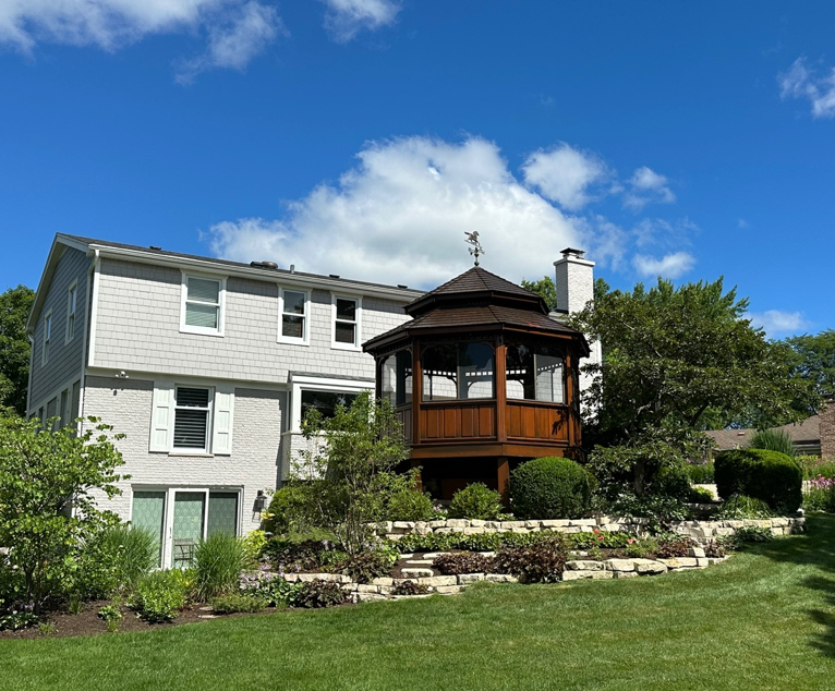 A large white house with a gazebo in the backyard.