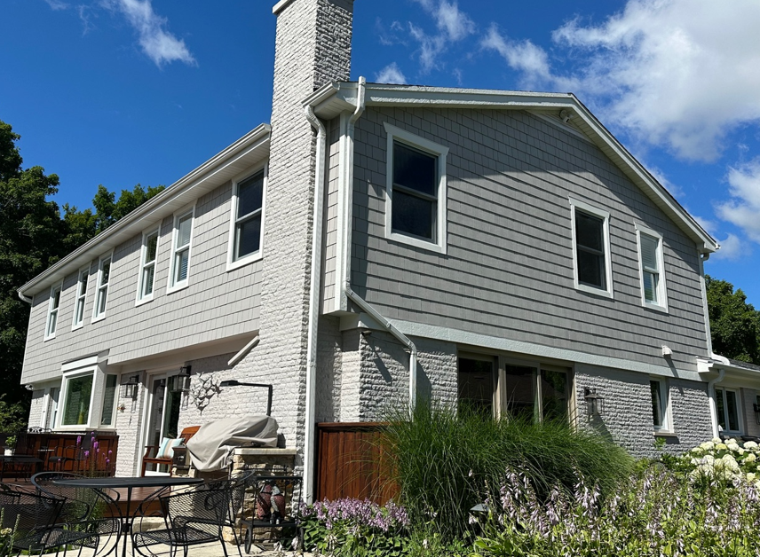 A large white house with a lot of windows and a chimney.
