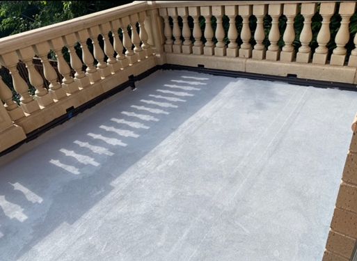 A balcony with a railing and a concrete floor