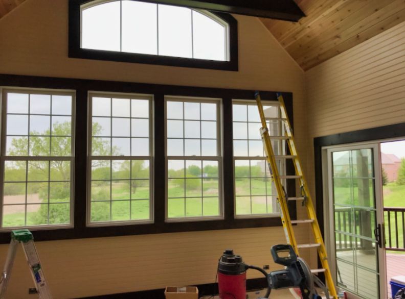 A room with a lot of windows and a ladder