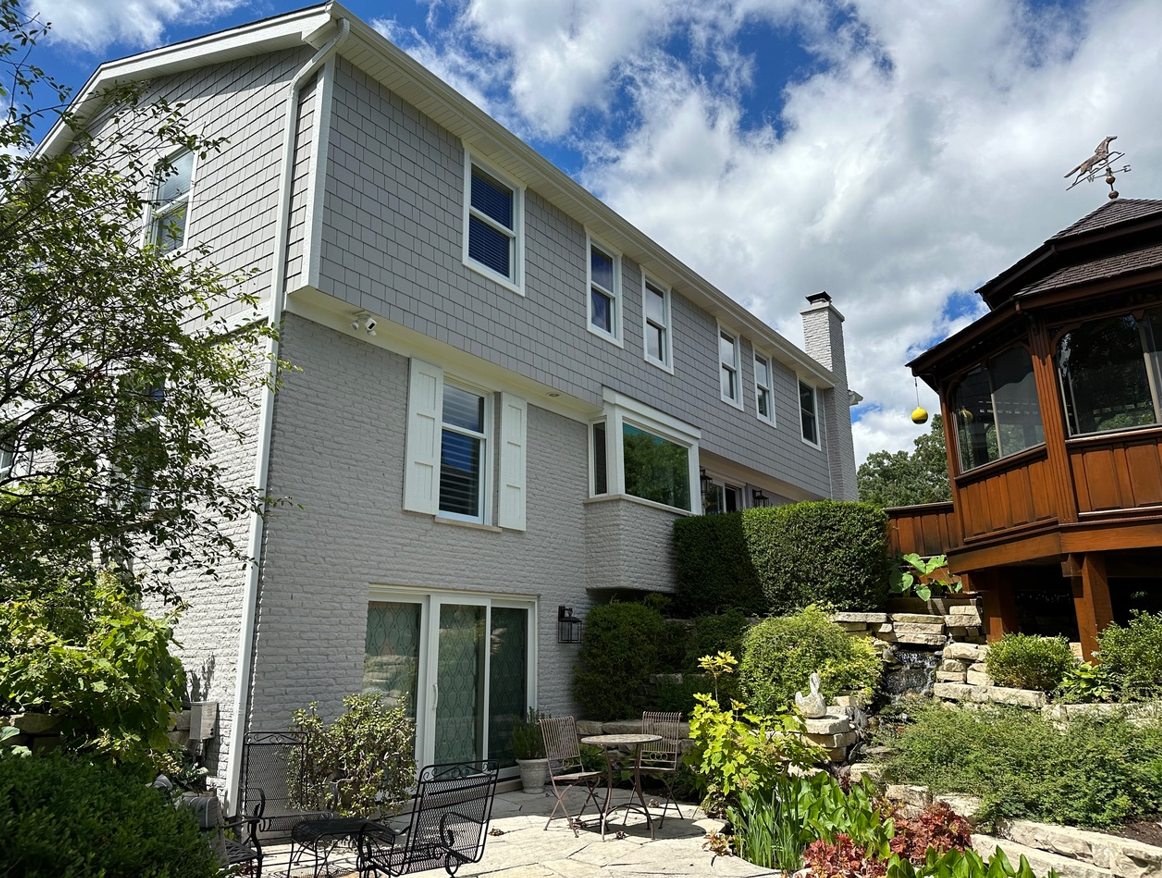 A large white house with a lot of windows and a patio in front of it.