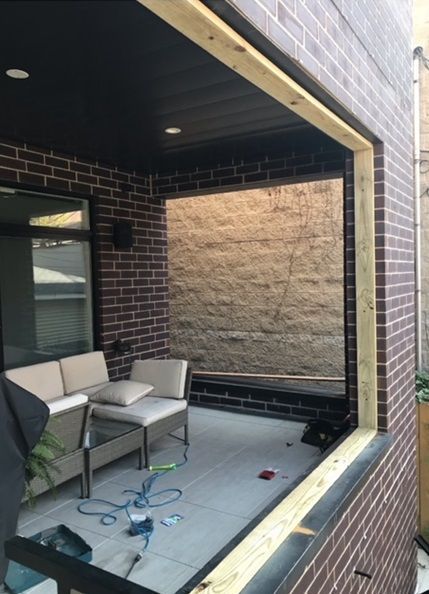 A brick building with a large window under construction