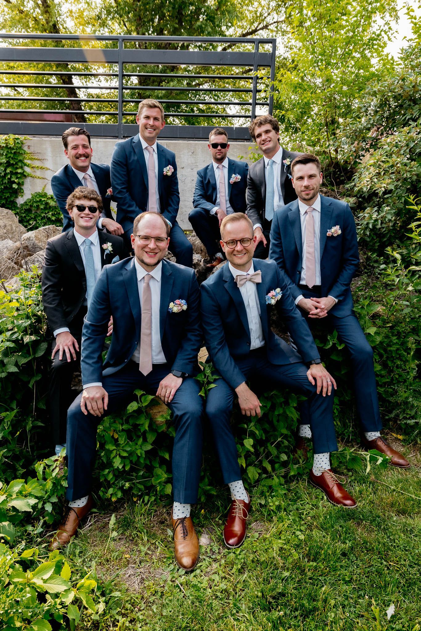 A group of men in suits and bow ties are posing for a picture