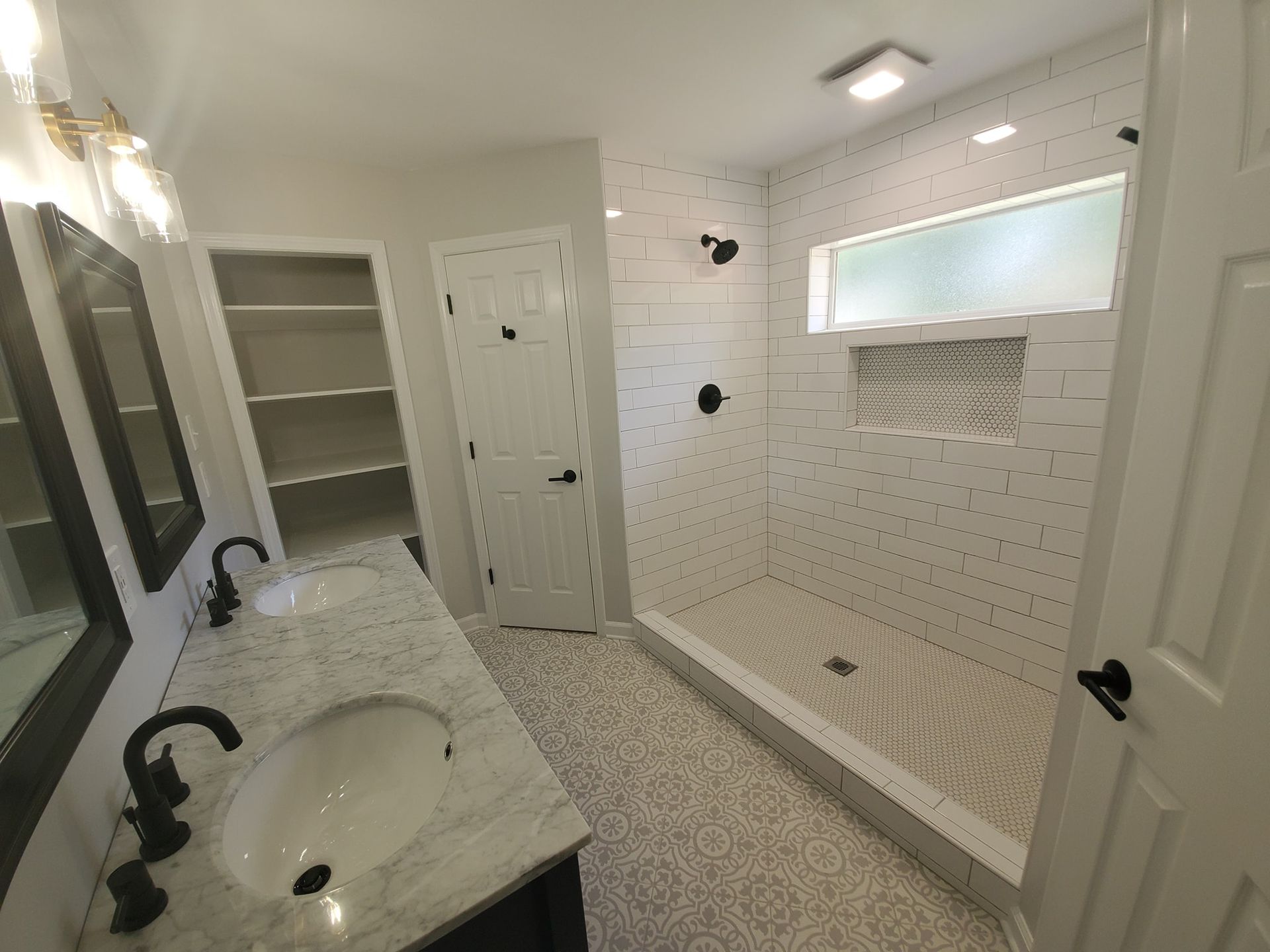 A bathroom with a sink and a walk in shower.