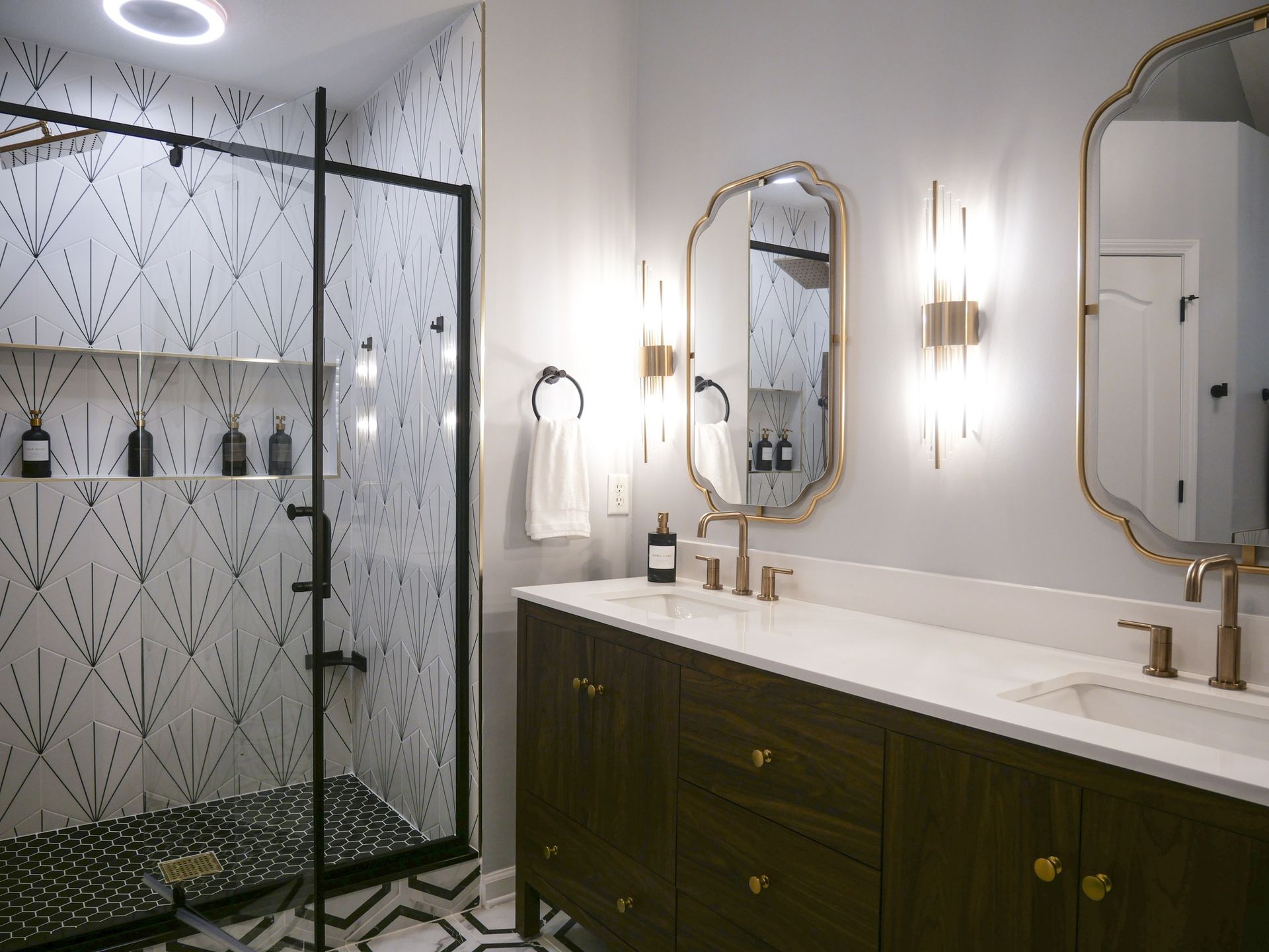 A bathroom with two sinks , a shower and two mirrors.