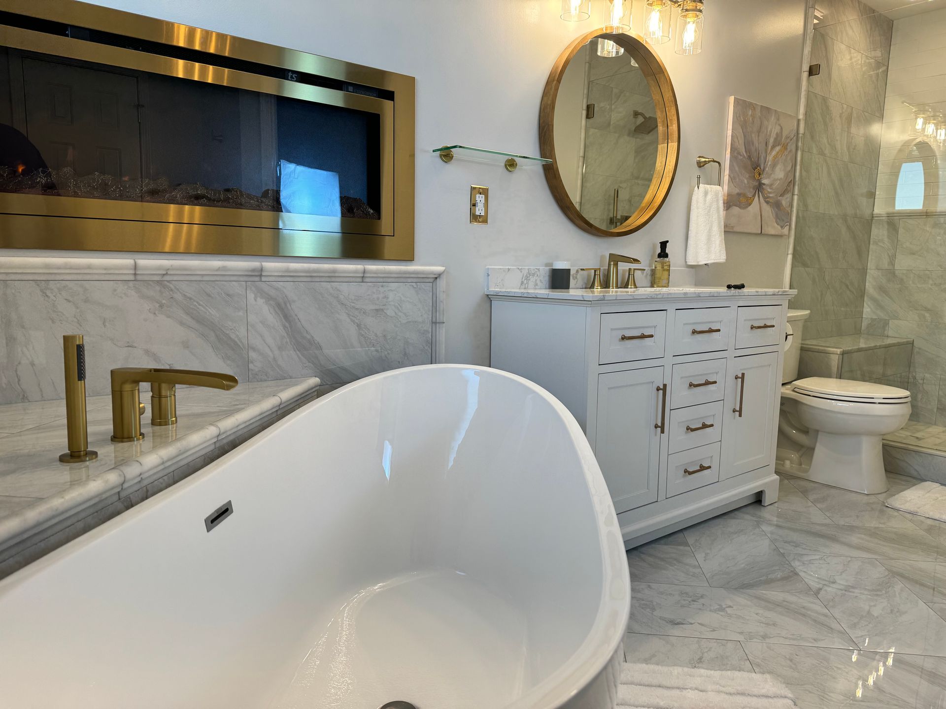 A bathroom with a tub , sink , toilet and fireplace.