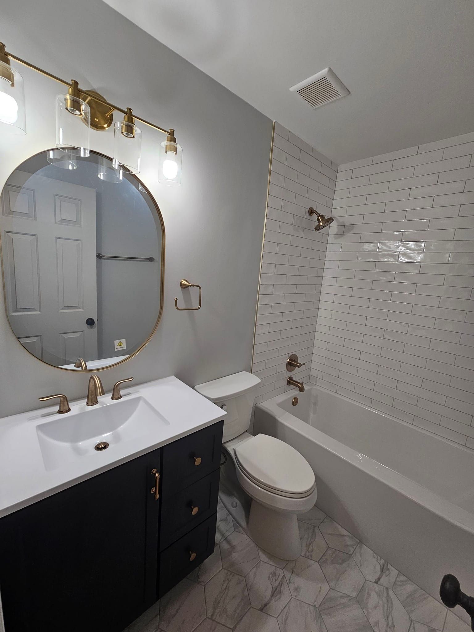 A bathroom with a sink , toilet , bathtub and mirror.