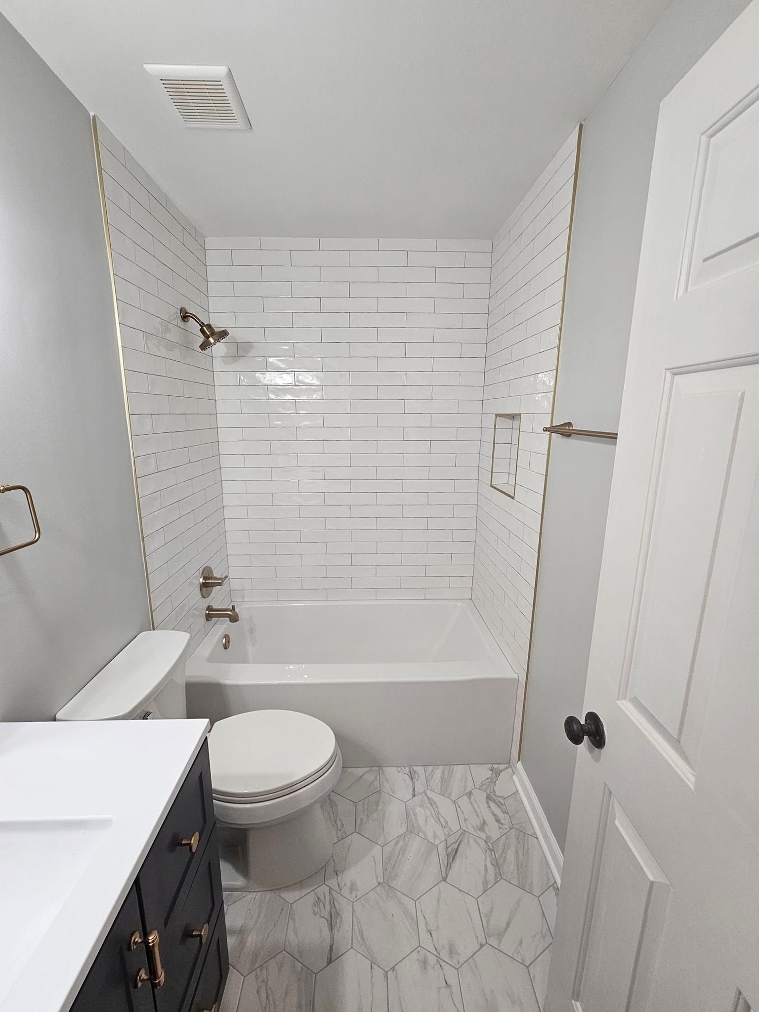 A bathroom with a toilet , sink , and bathtub.