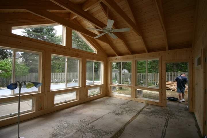 A house with a screened in porch on the side of it.