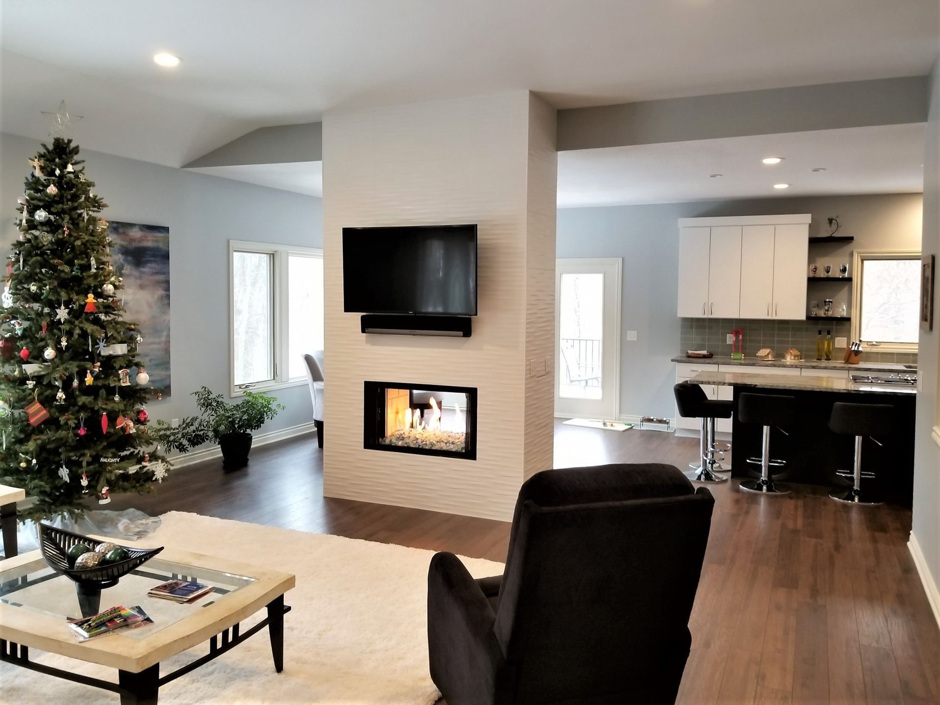 A living room with a fireplace and a christmas tree