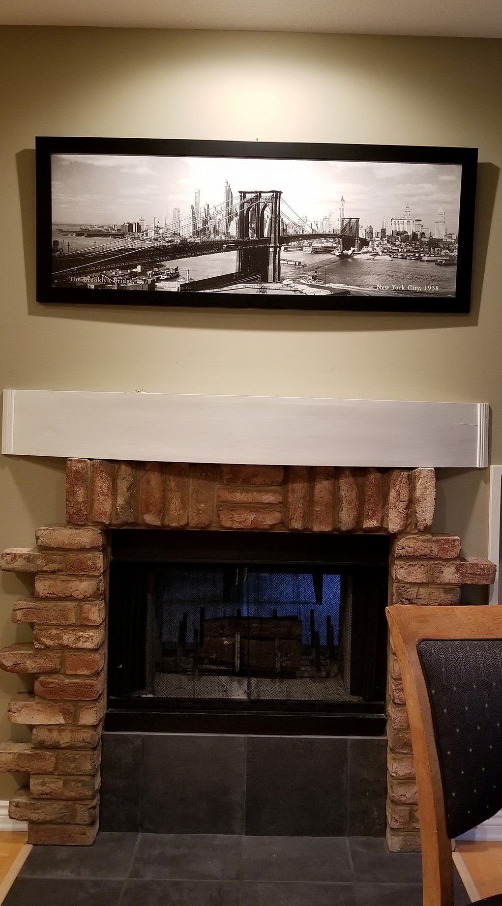 A fireplace with a picture on the wall above it.