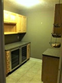 A kitchen with wooden cabinets and a refrigerator.