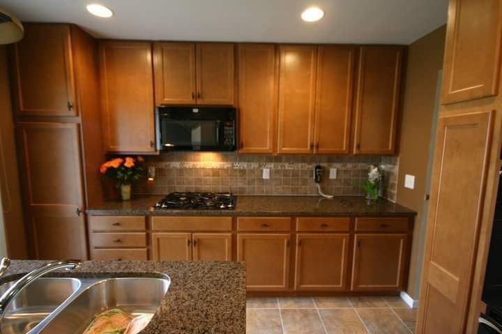 A kitchen with wooden cabinets and granite counter tops