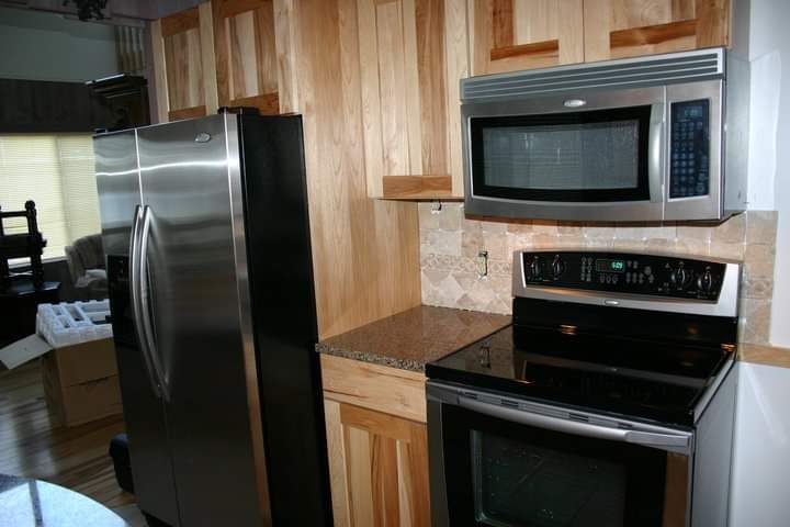 A kitchen with a refrigerator , stove and microwave.