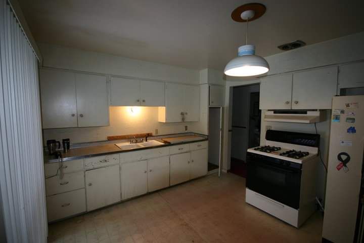 A kitchen with white cabinets and a black stove