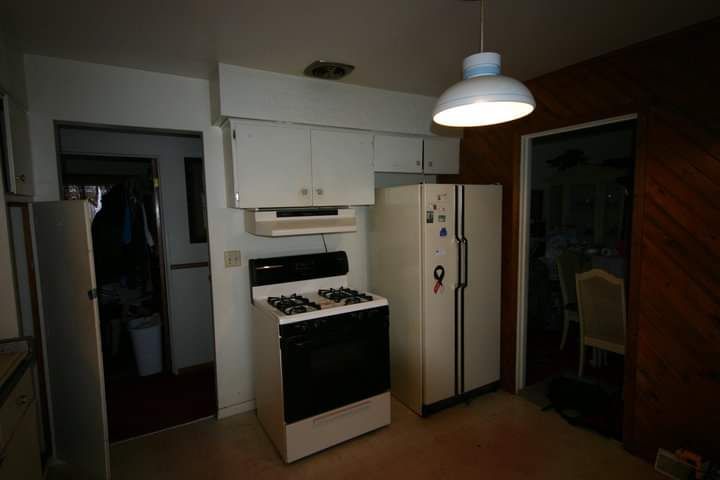 A kitchen with a white stove and refrigerator