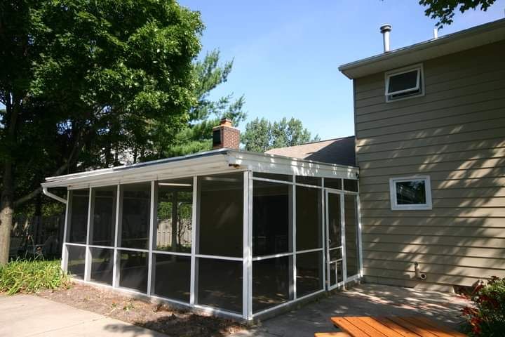 A screened in porch next to a house