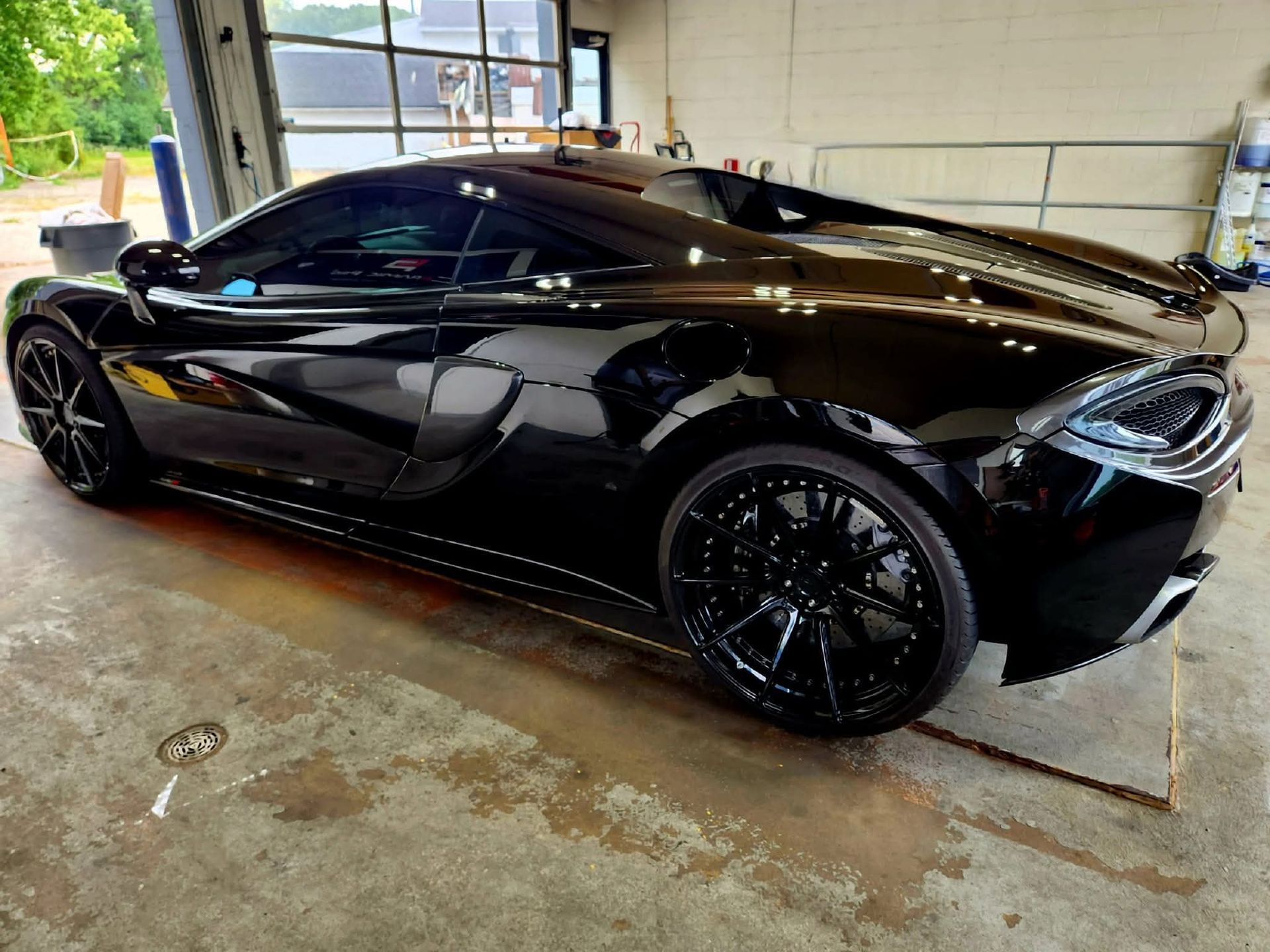 Black McLaren sports car parked inside a garage.
