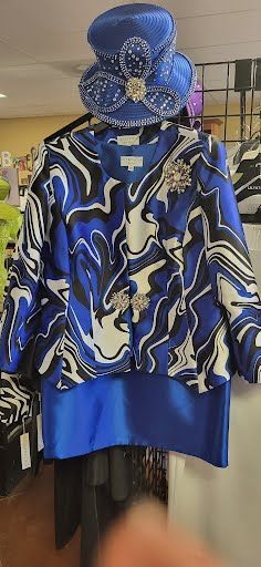 printed long-sleeved blouse, plain blue skirt, and a blue hat