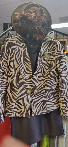 long-sleeved blouse with animal print, plain black skirt, and a black hat