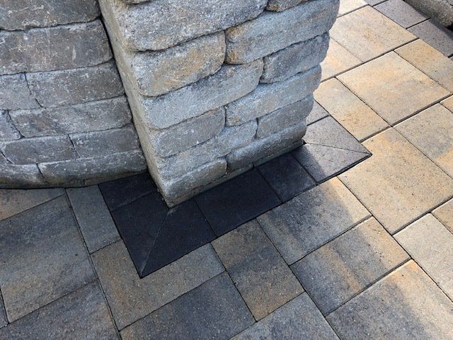 A brick wall is surrounded by a brick patio.