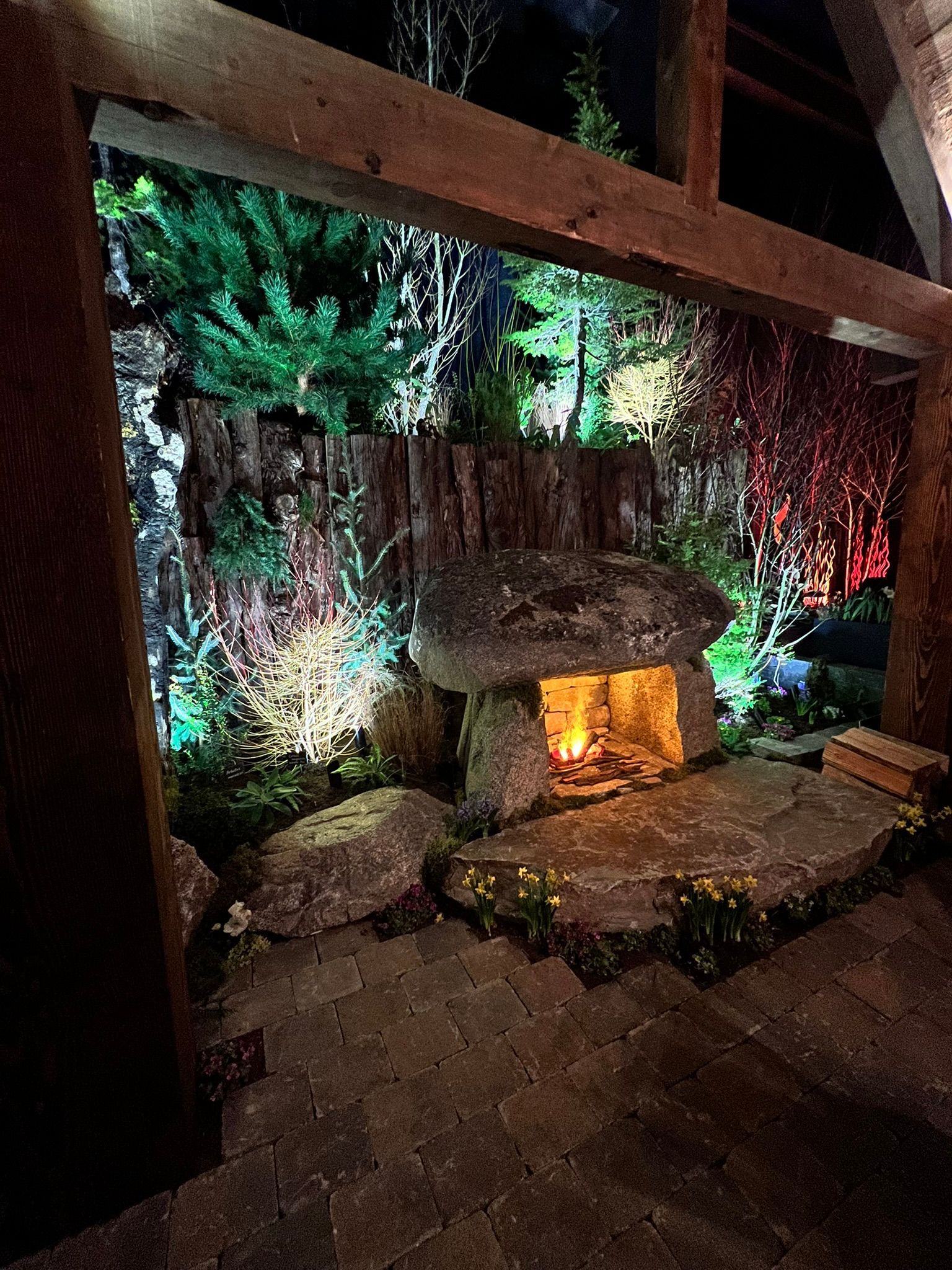 There is a fireplace in the middle of the garden at night.