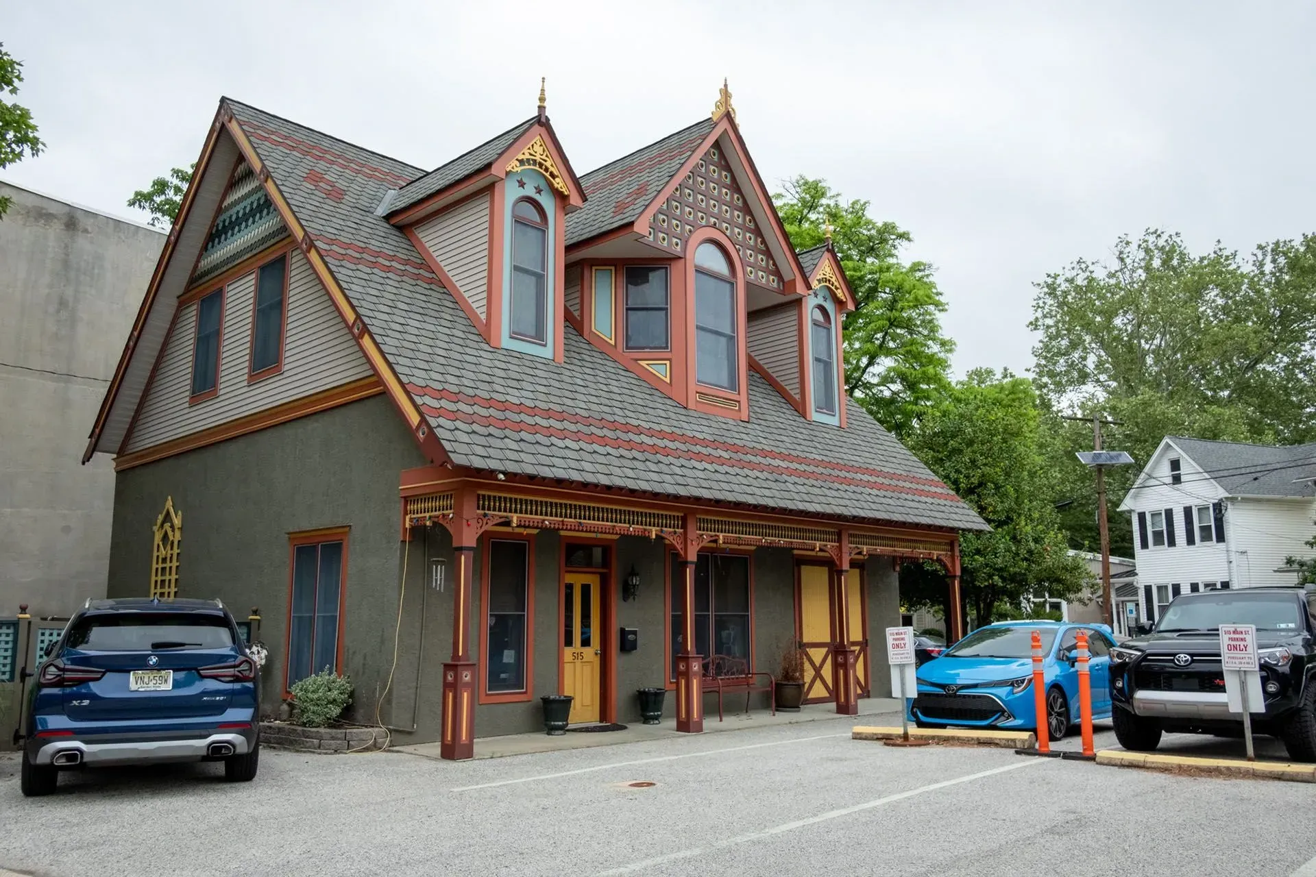 A two-story building with a decorated facade and parking in front.