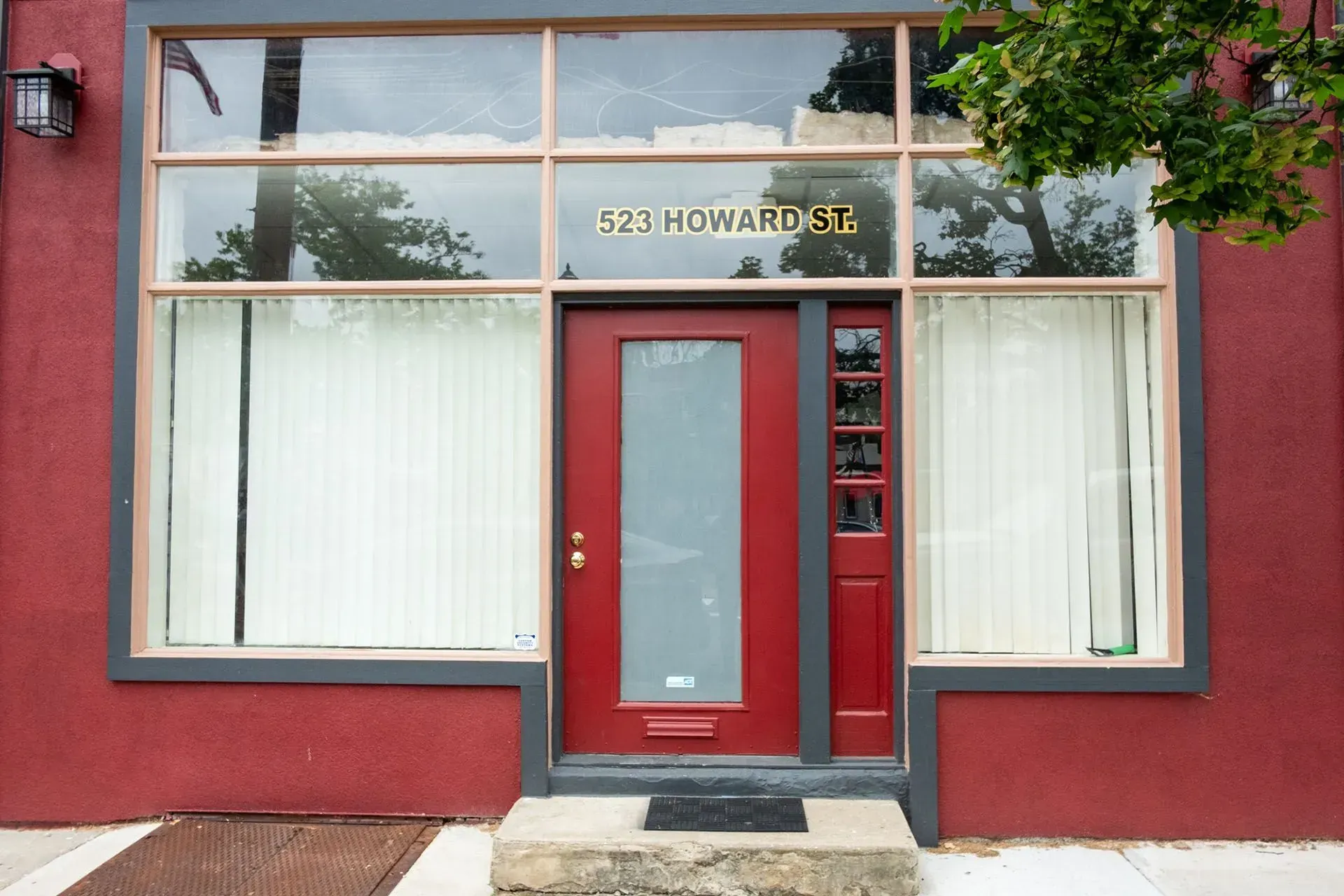 Red storefront with glass windows and door, marked 