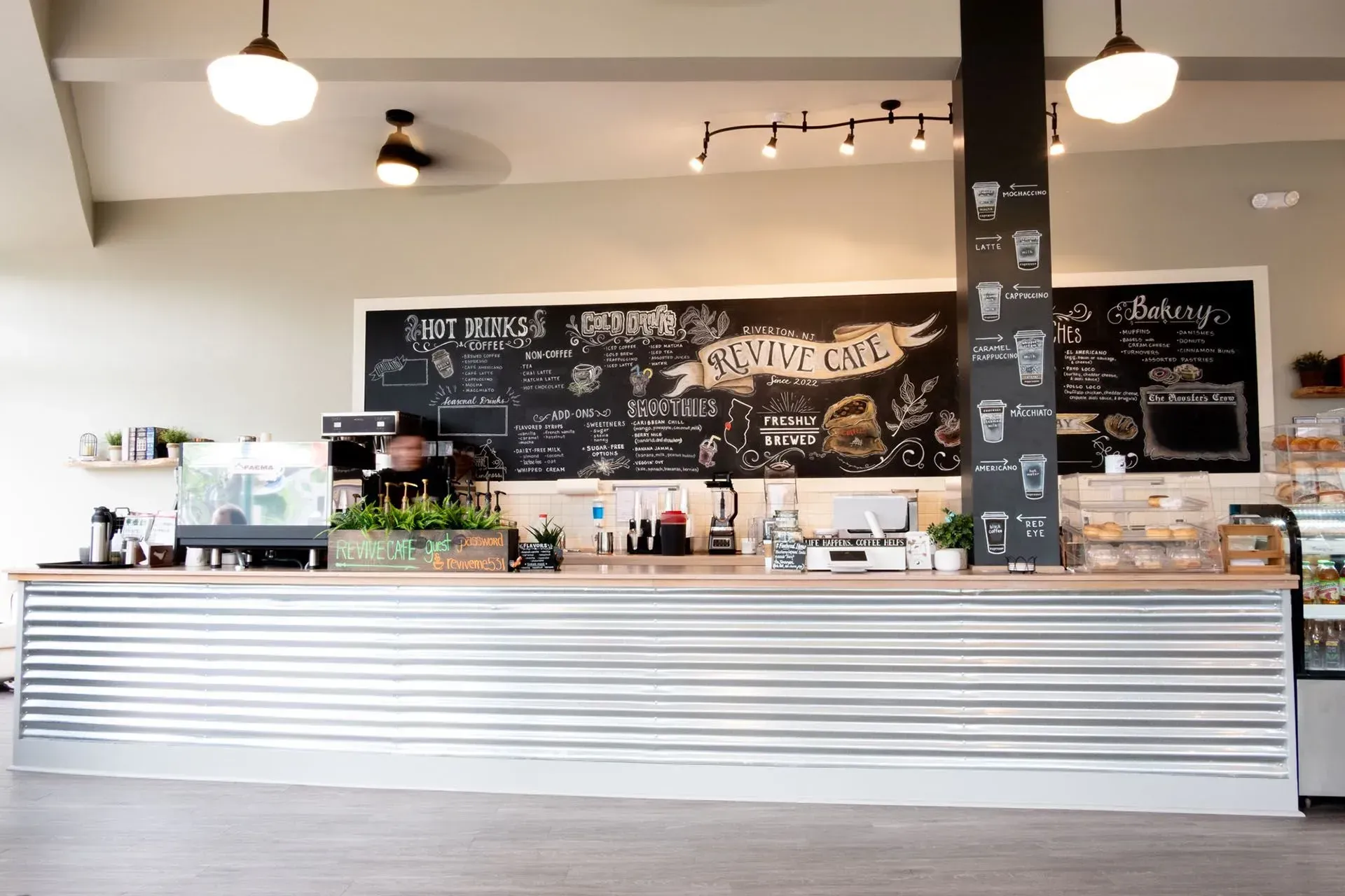 Coffee shop counter with corrugated metal front and chalkboard menu.