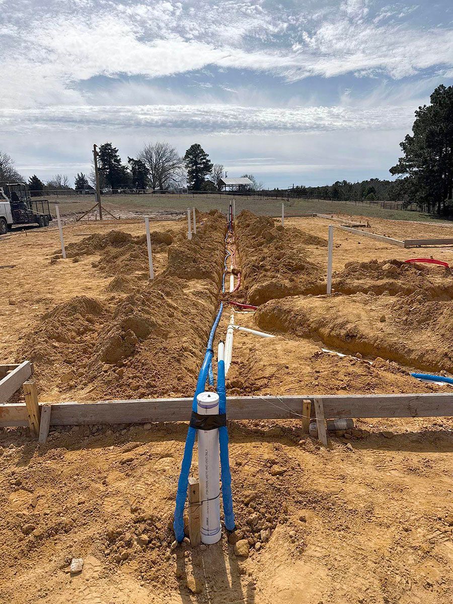 A construction site with a lot of dirt and pipes in the ground