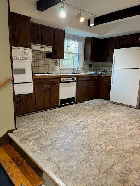 A kitchen with wooden cabinets and a white refrigerator